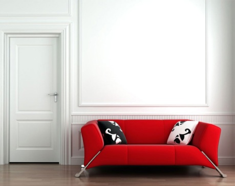 Röd soffa mot vit vägg...